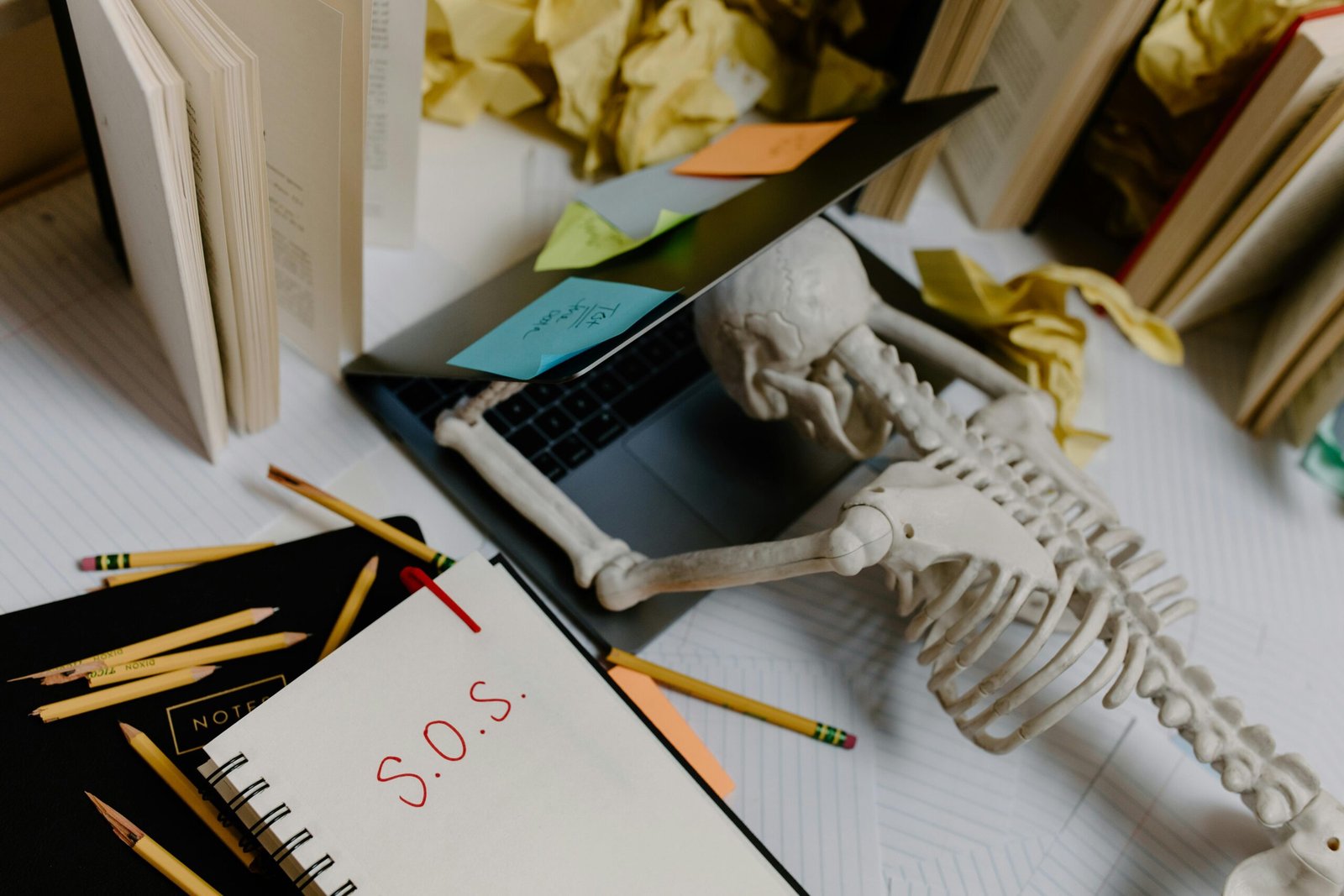 Skeleton working on laptop representing entrepreneur burnout before hiring virtual assistant support